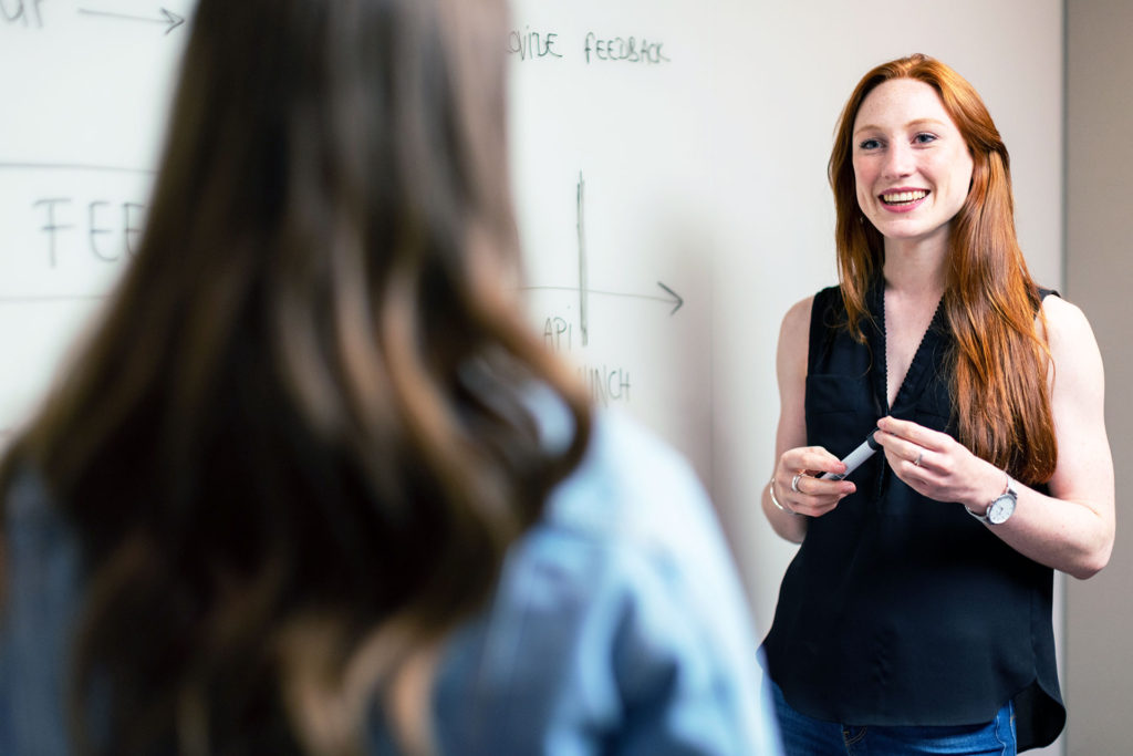 Two Woman Brainstorming Together with Whiteboard